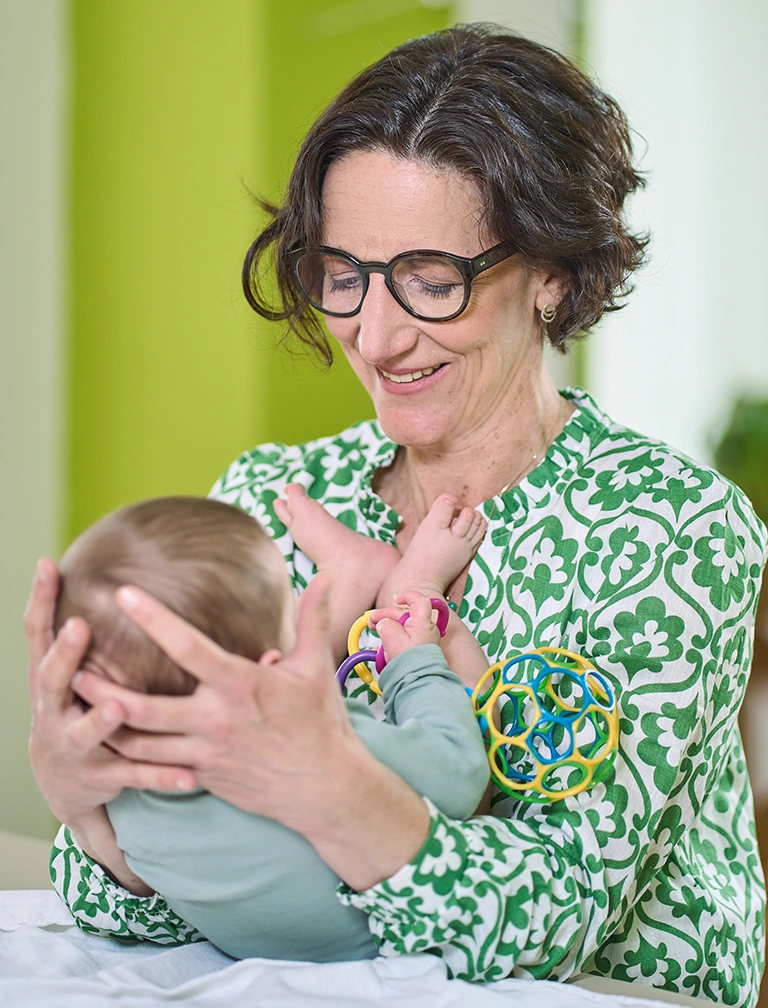 Osteopathin mit Baby auf dem Arm