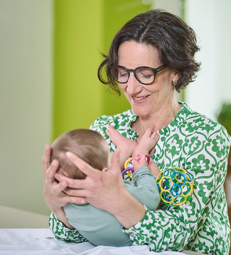 Osteopathin mit Baby auf dem Arm