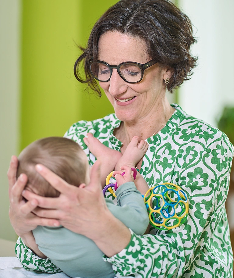 Osteopathin mit Baby auf dem Arm